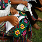 Mujer bordando logo de Yolia